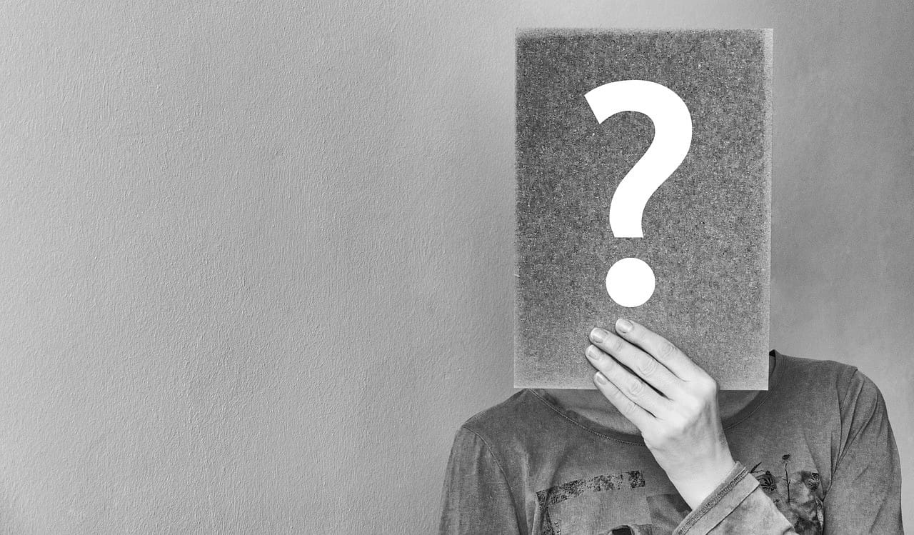 question-2736480_1280 person hiding their face behind a question mark sign